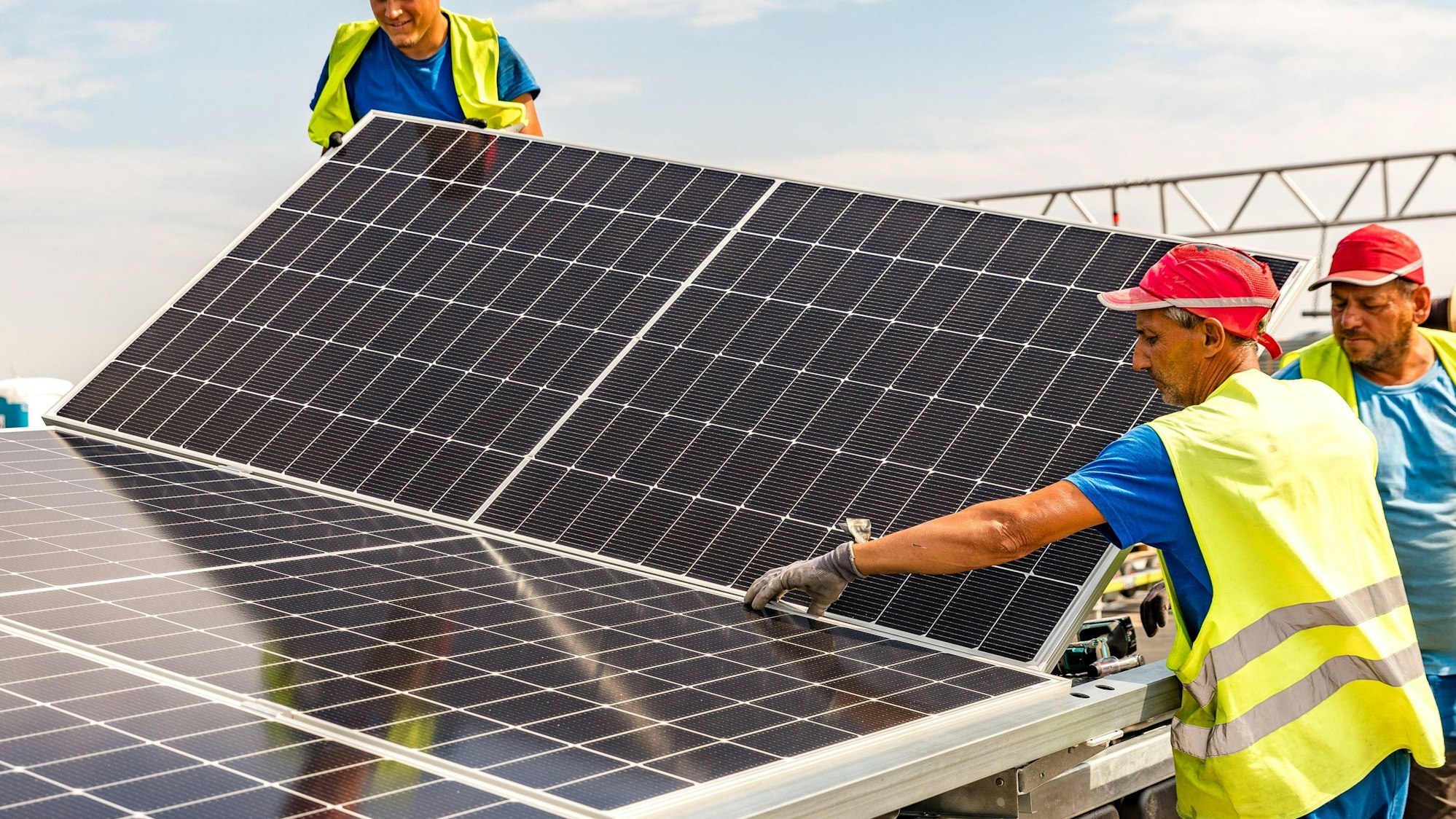 15.08.2024, Brandenburg, Neuendorf: Arbeiter der Firma Pfalzsolar montieren Solarmodule für die Floating PV-Anlage auf dem Cottbuser Ostsee.