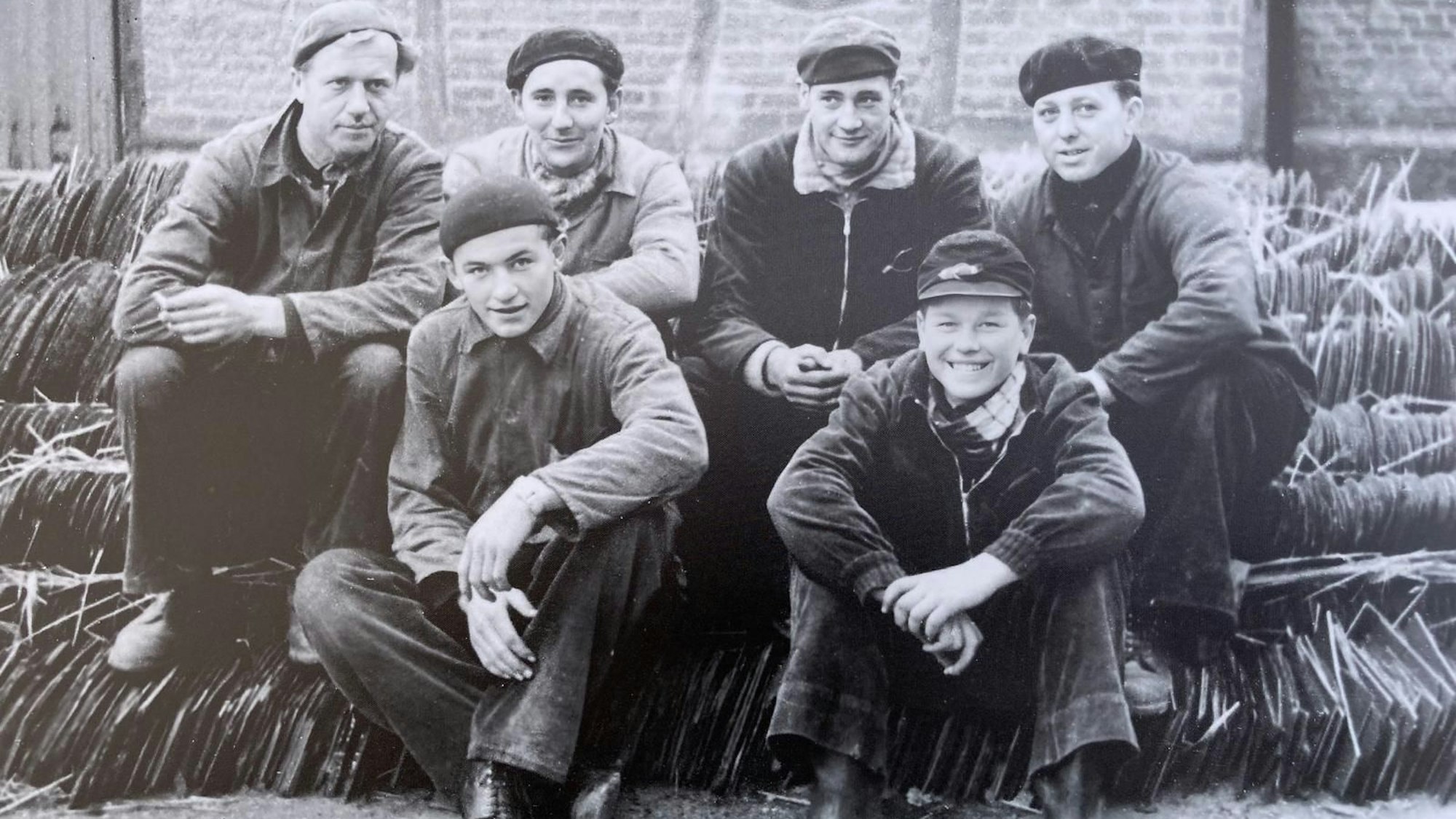Handwerker sitzen in einem Schwarz-Weiß-Gruppenfoto zusammen.