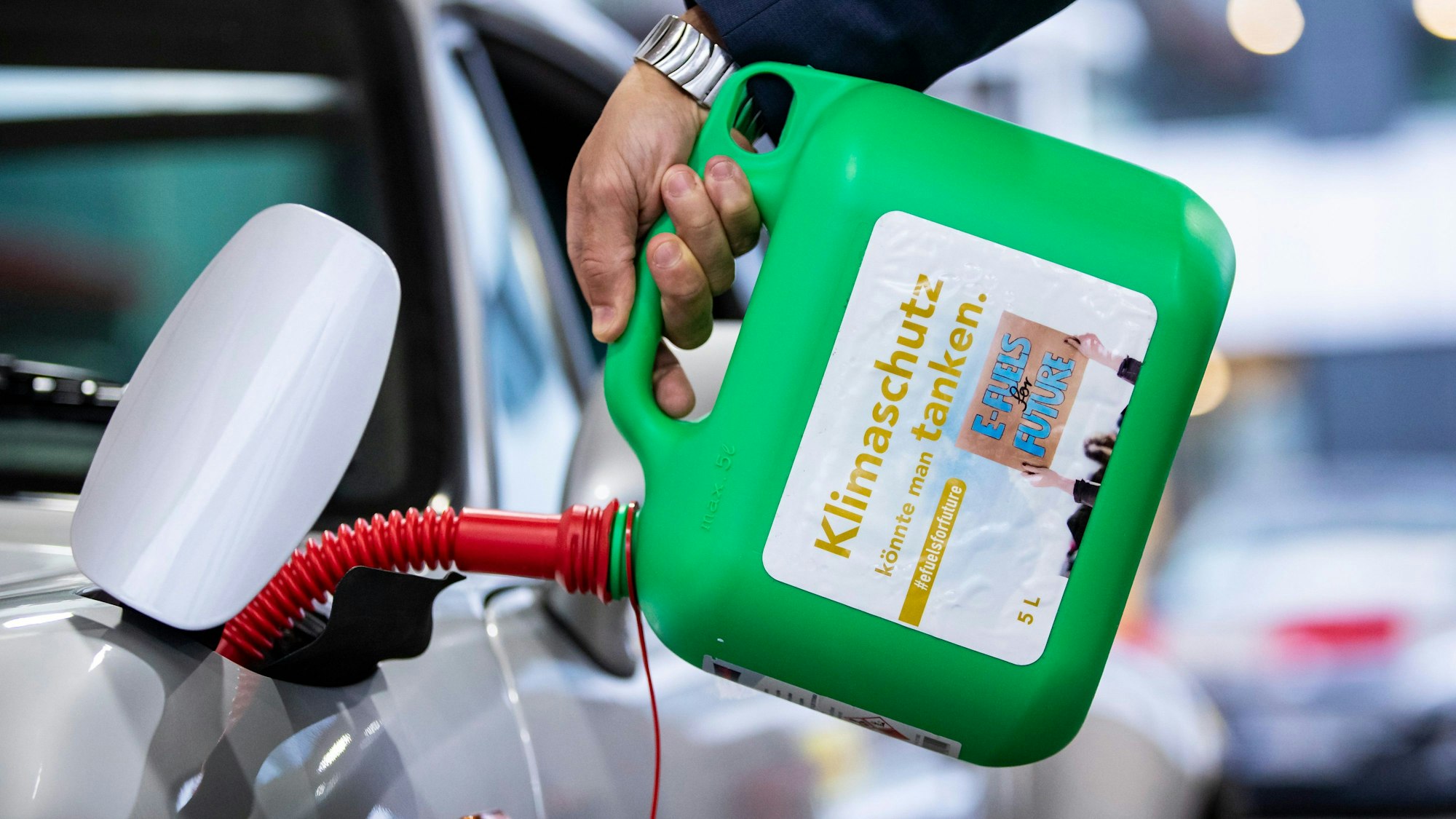 Stuttgart: Ein Auto wird mit einem Kanister mit der Aufschrift „Klimaschutz könnte man Tanken - E-Fules for Future“ an einer Tankstelle mit E-Fuel betankt.