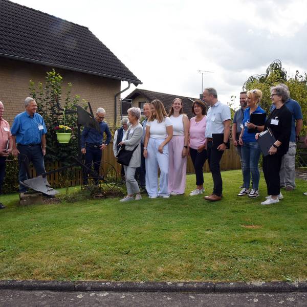 Eine Gruppe steht auf einer Wiese zusammen.