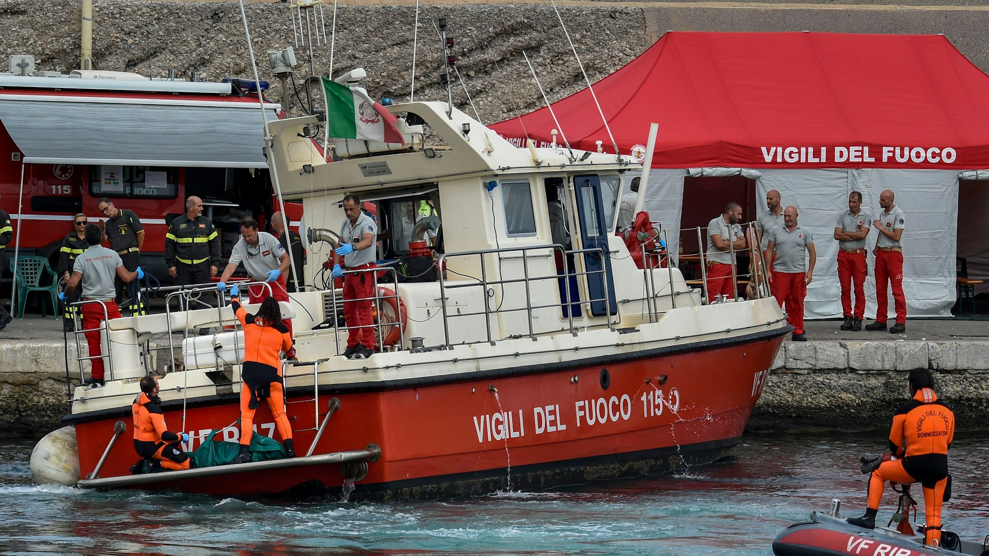 Taucher der italienischen Feuerwehr bringen die Leiche eines der Opfer des Unglücks der „Bayesian“, in einem grünen Sack an Land.