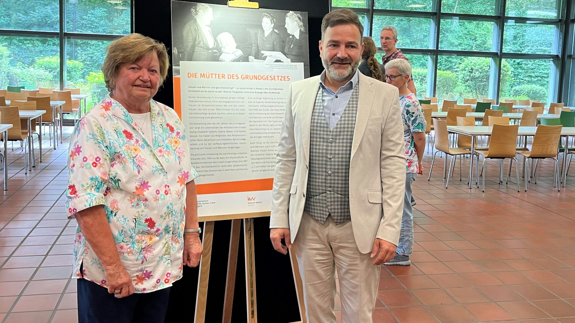 Die beiden stehen nebeneinander vor einer der Informationstafeln.