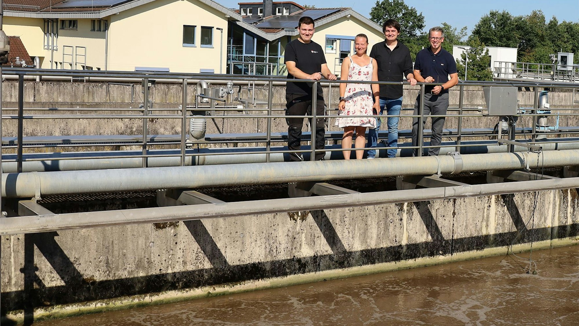 Fachkraft Abwassertechnik, Nils Weller, Fachbereichsleitung Abwasserbetrieb, Dana Schmetkamp, Bürgermeister Mario Dahm und Betriebsleiter Dr. Volker Erbe (v.l.) stehen vor einem Belebungsbecken.