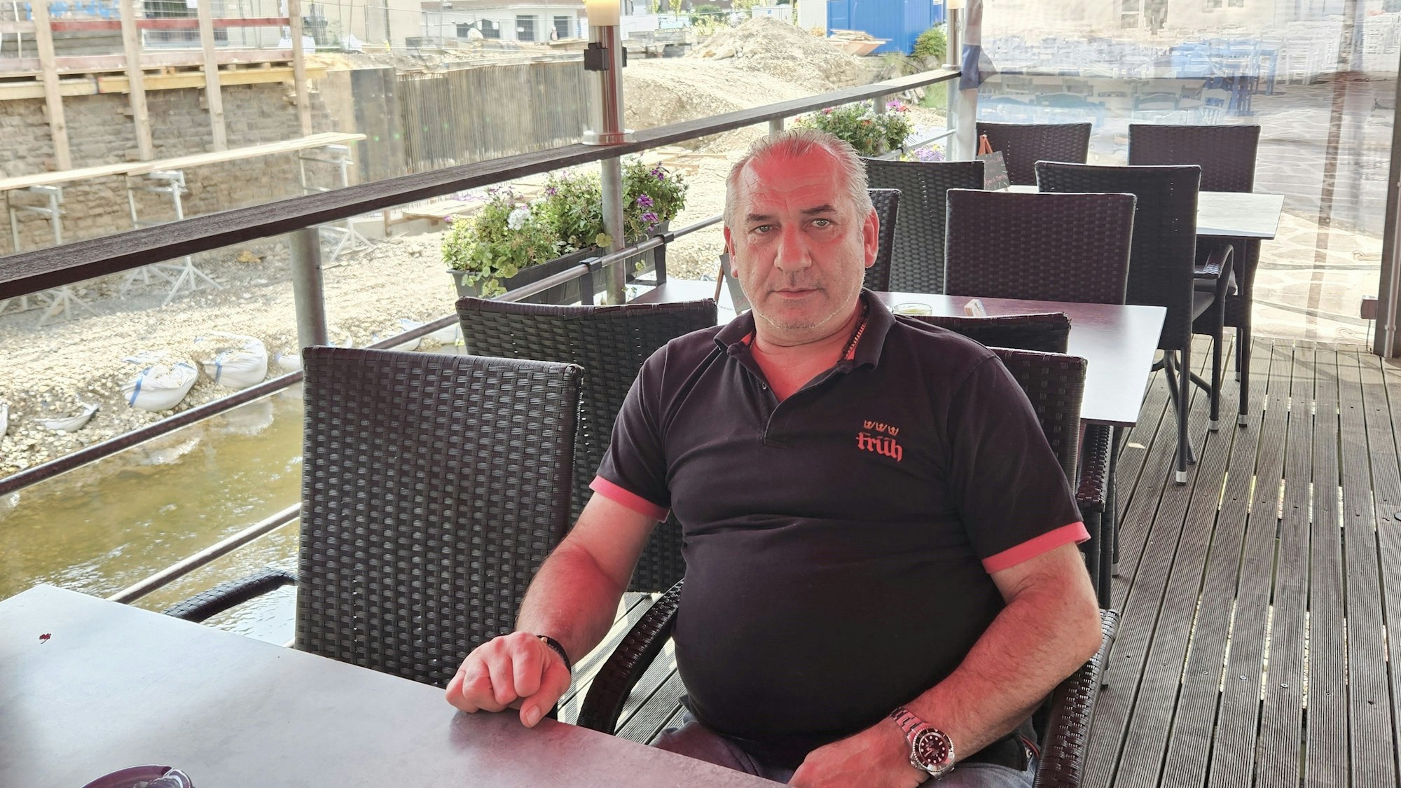 Thomas Balatsouras sitzt an einem Tisch auf der Terrasse.