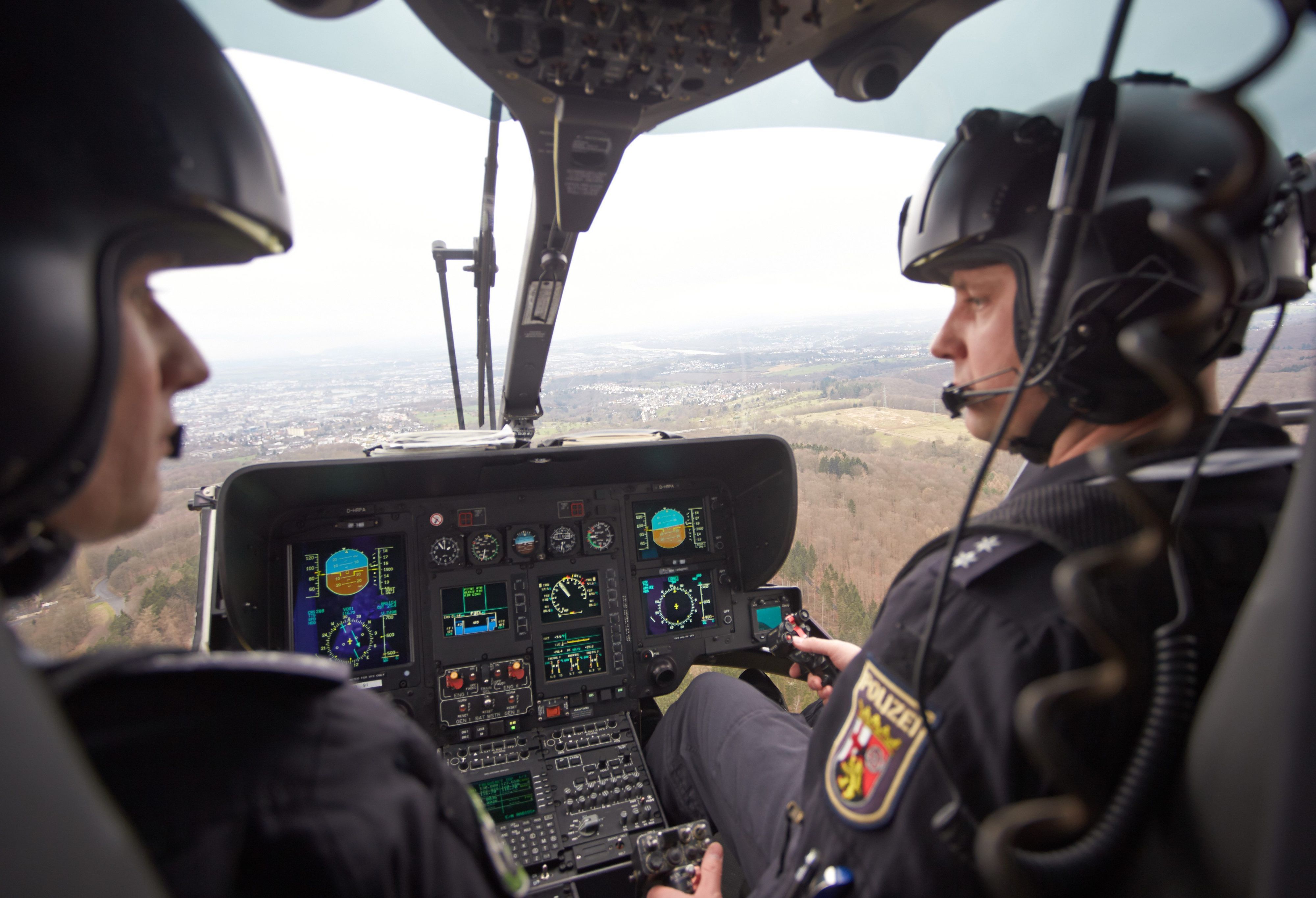 ARCHIV - 02.03.2016, Rheinland-Pfalz, Winningen: Die Polizei-Hubschrauberpiloten Christian Lange (r) und Thomas Meyer fliegen am 03.03.2016 mit einem Polizeihubschrauber vom Typ Eurocopter H 135 über Koblenz (Rheinland-Pfalz).