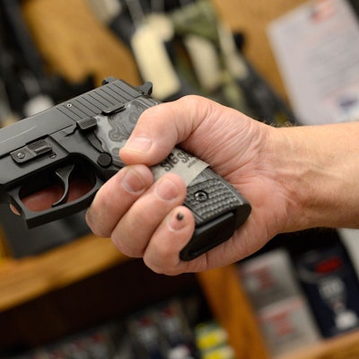 Eine Hand hält eine Waffe.