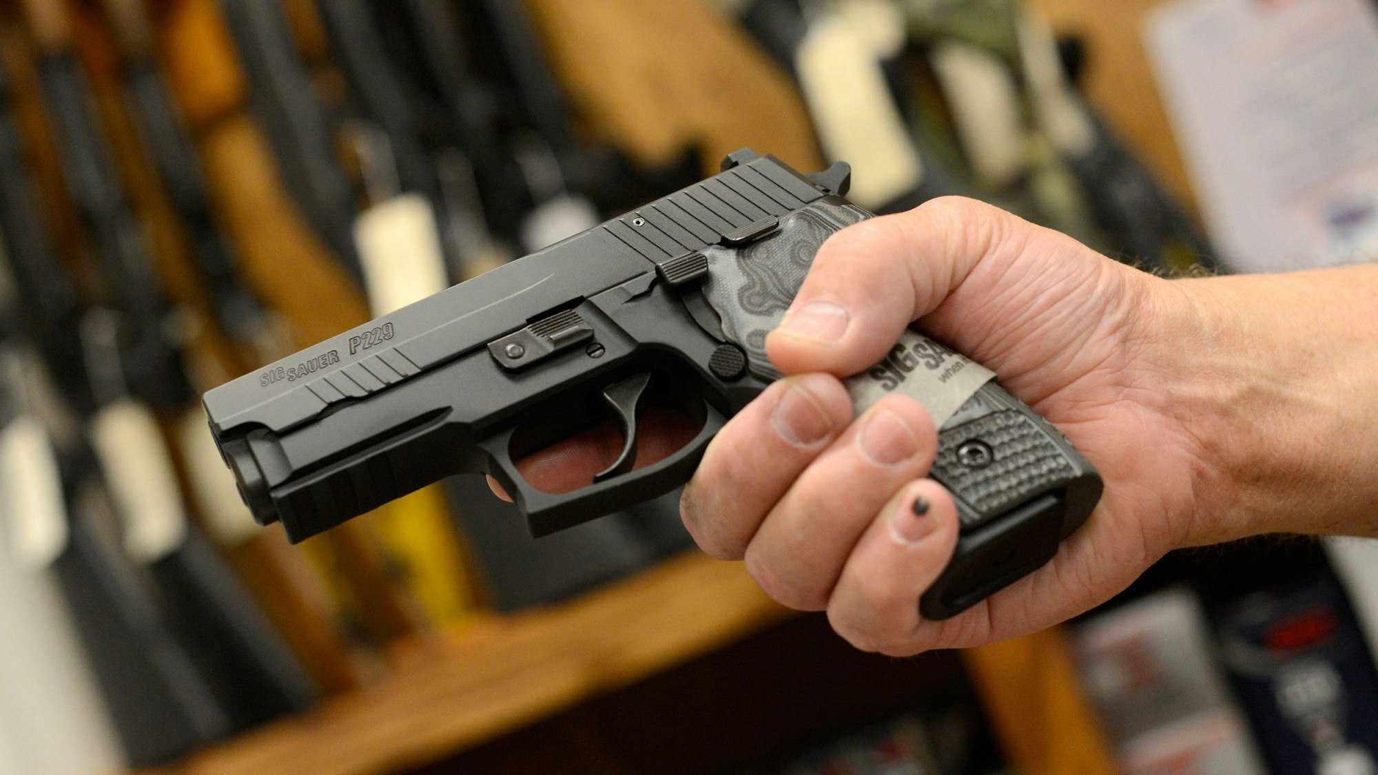 Eine Hand hält eine Waffe.