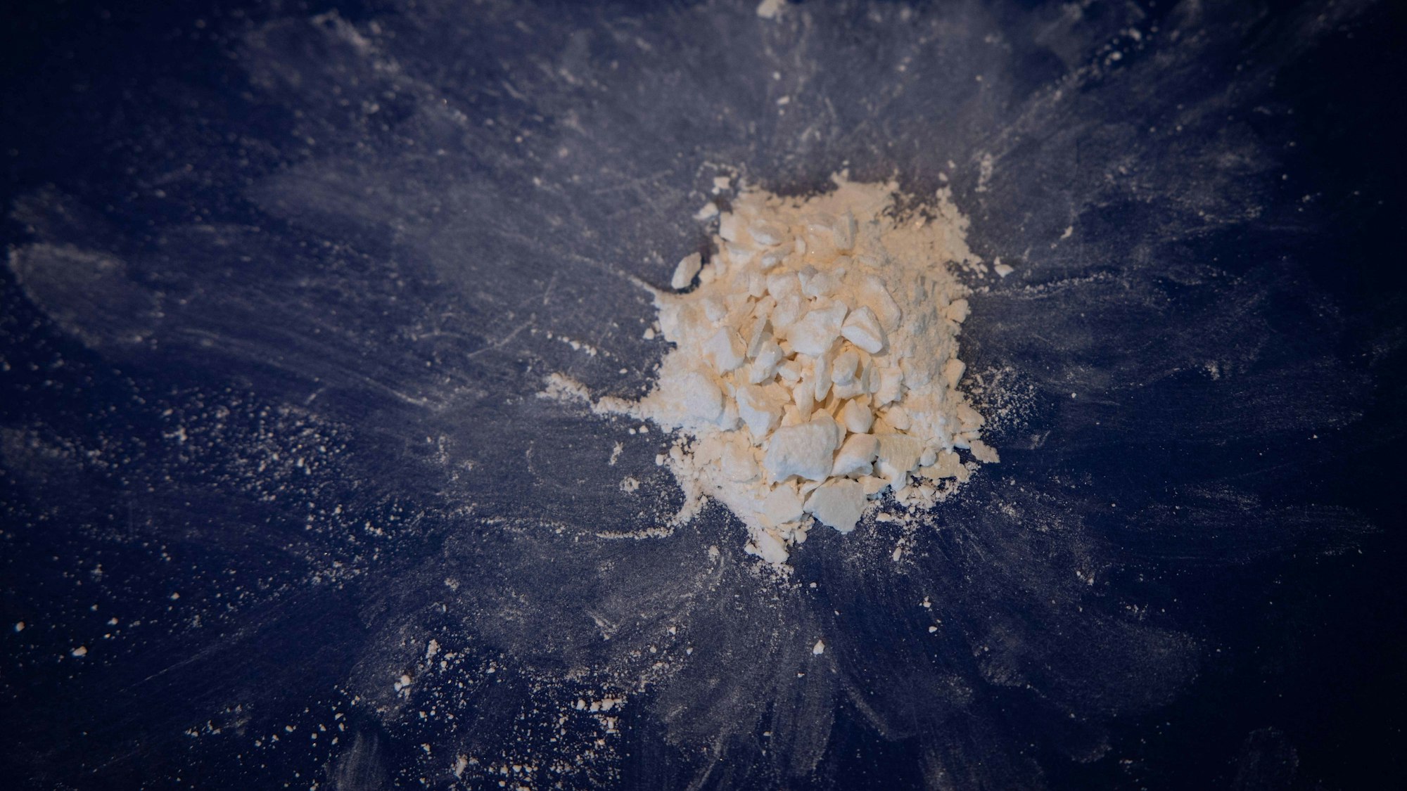 Auf einer schwarzen Unterlage liegt Kokain.