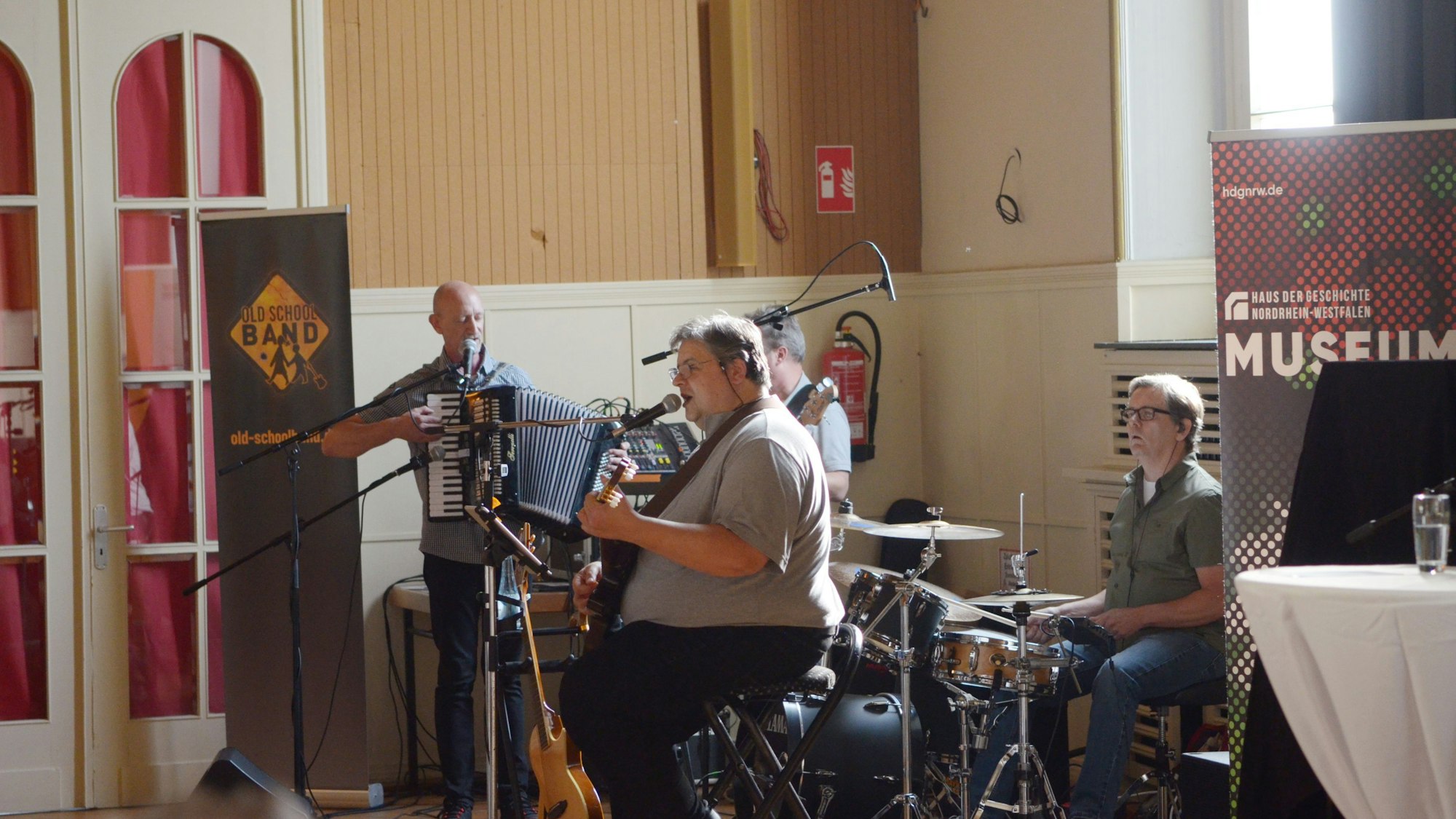 Die Musiker mit Gitarre, Bass, Akkordeon und Schlagzeug.