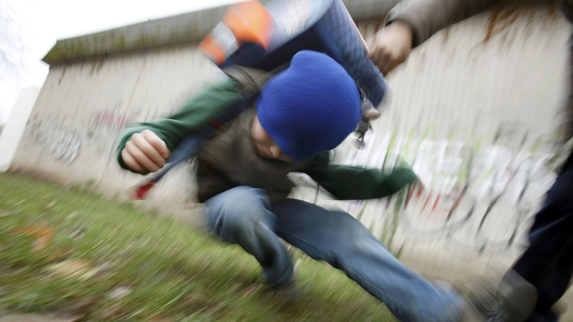 Ein Schüler drückt einen anderen Schüler zu Boden (gestelltes Illustrationsfoto).