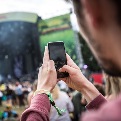 Ein Festivalbesucher fotografiert mit seinem Handy.