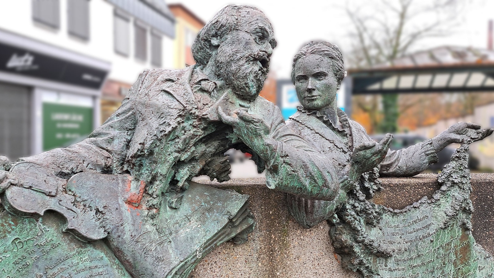 Ein Bronzedenkmal mit den Köpfen von Max Bruch und Maria Zanders auf einem Betonsockel in der Bergisch Gladbacher Innenstadt.