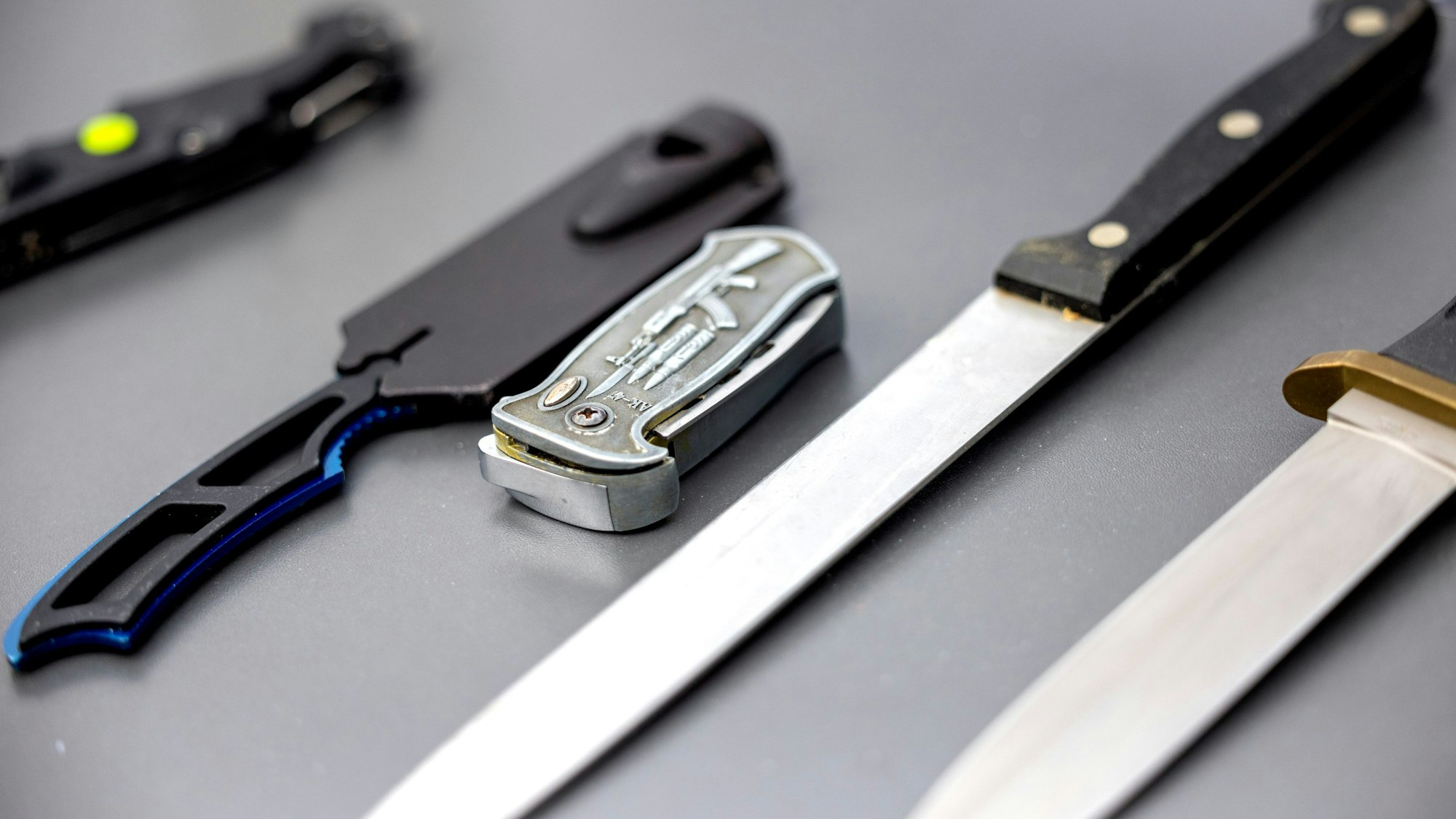 Köln: Auf einem Tisch liegen von der Polizei sichergestellte verbotene Stichwaffen.