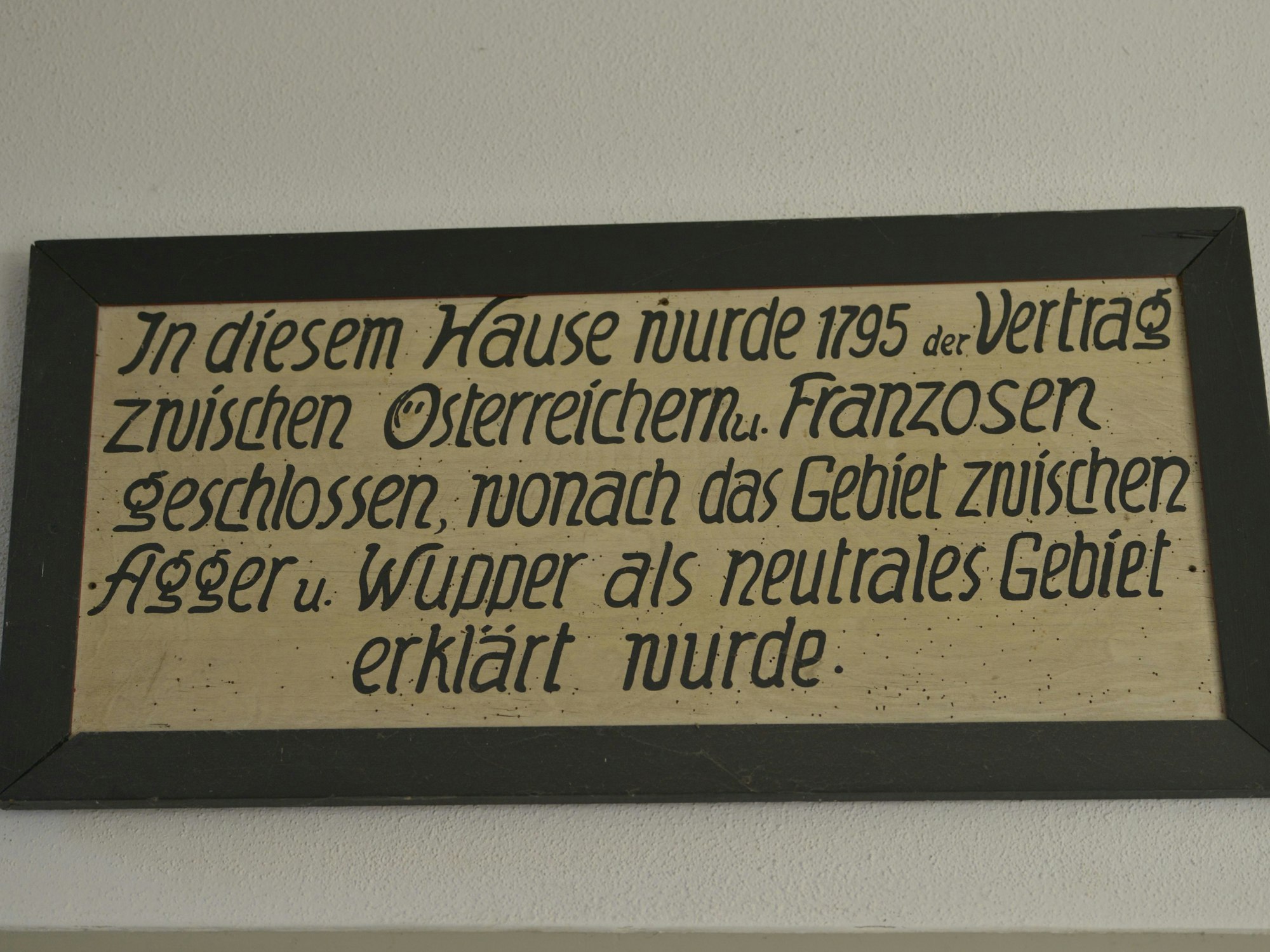 Das Schild erinnert an den Friedenschluss, der in dem Gebäude unterzeichnet wurde.