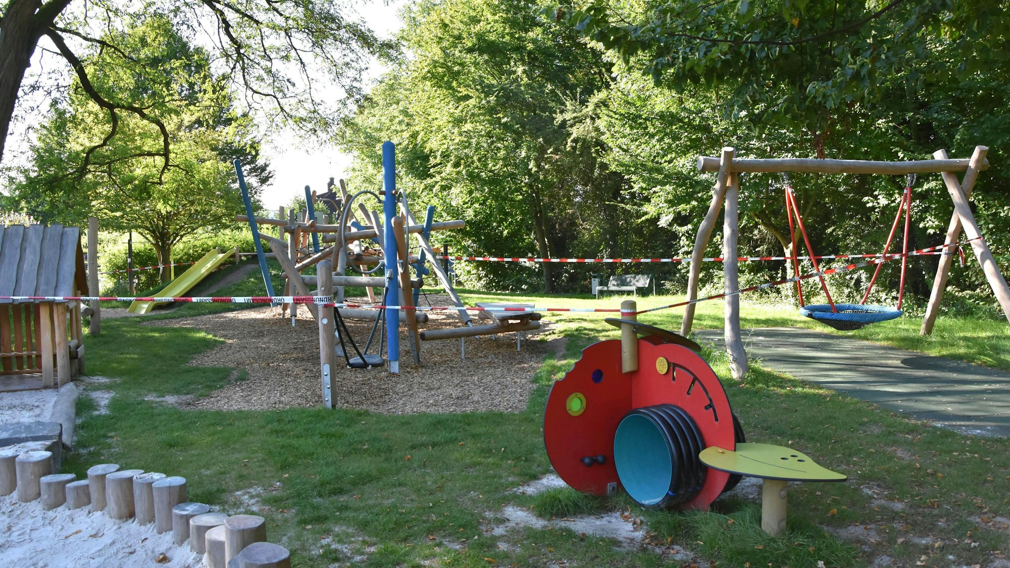 Zu sehen ist ein Spielplatz, der von rotem Flatterband abgesperrt.