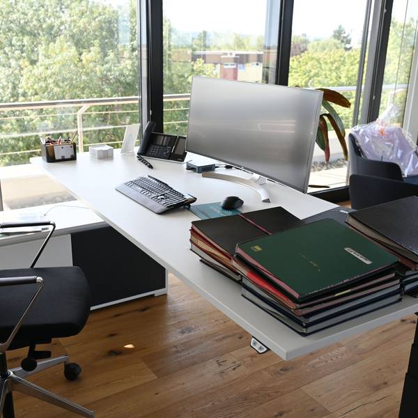 Auf dem Schreibtisch von Landrat Markus Ramers stehen ein Computerbildschirm, eine Tastatur und daneben liegen mehrere Aktenordner.