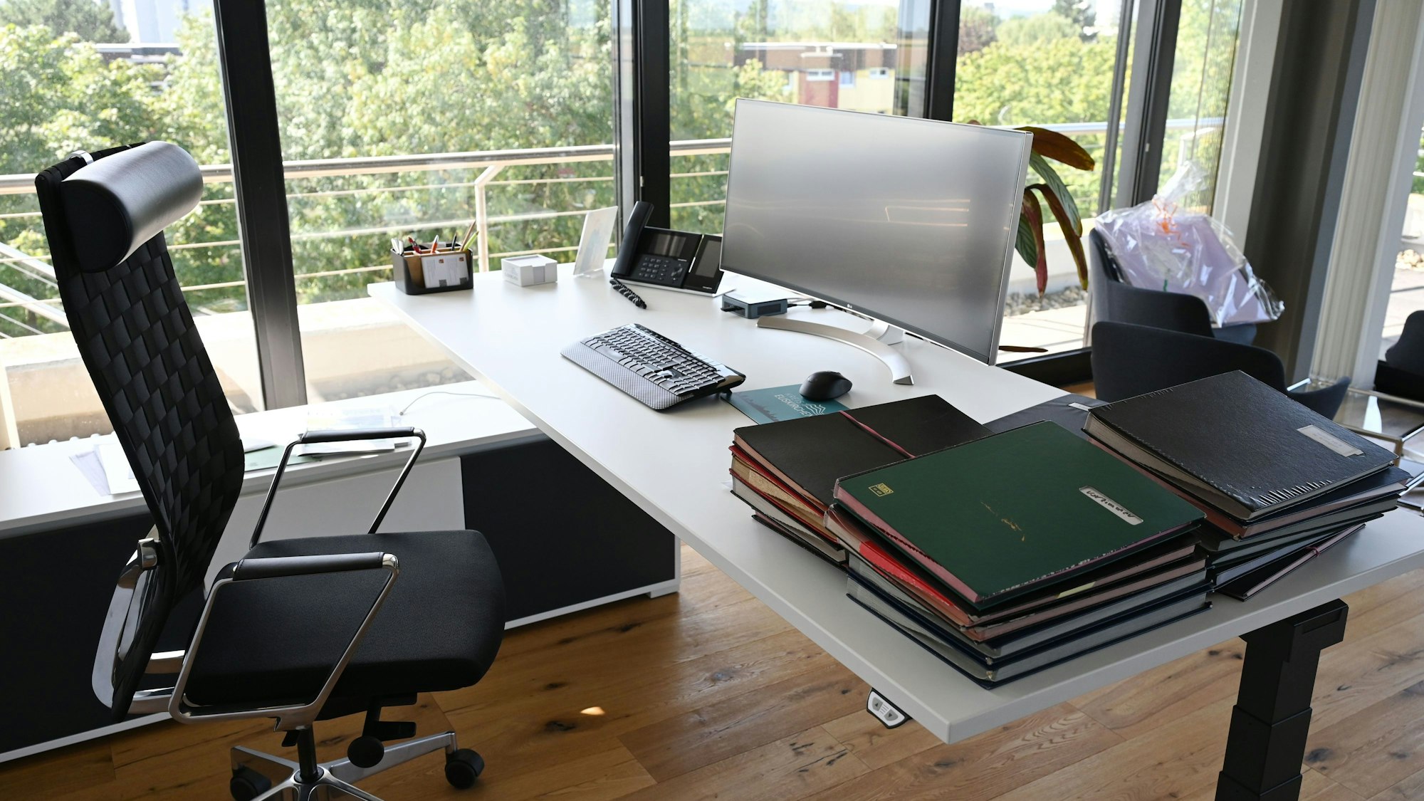 Auf dem Schreibtisch von Landrat Markus Ramers stehen ein Computerbildschirm, eine Tastatur und daneben liegen mehrere Aktenordner.