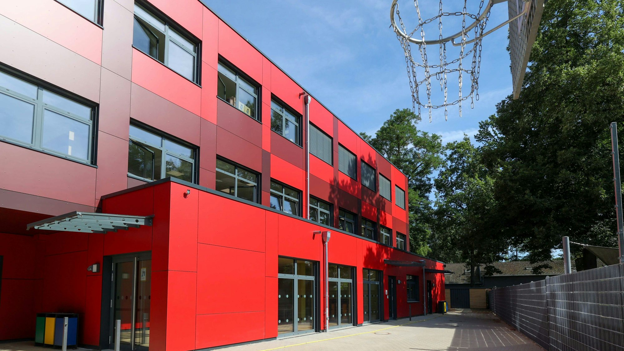 Ein rotes Schulgebäude in Modulbauweise.