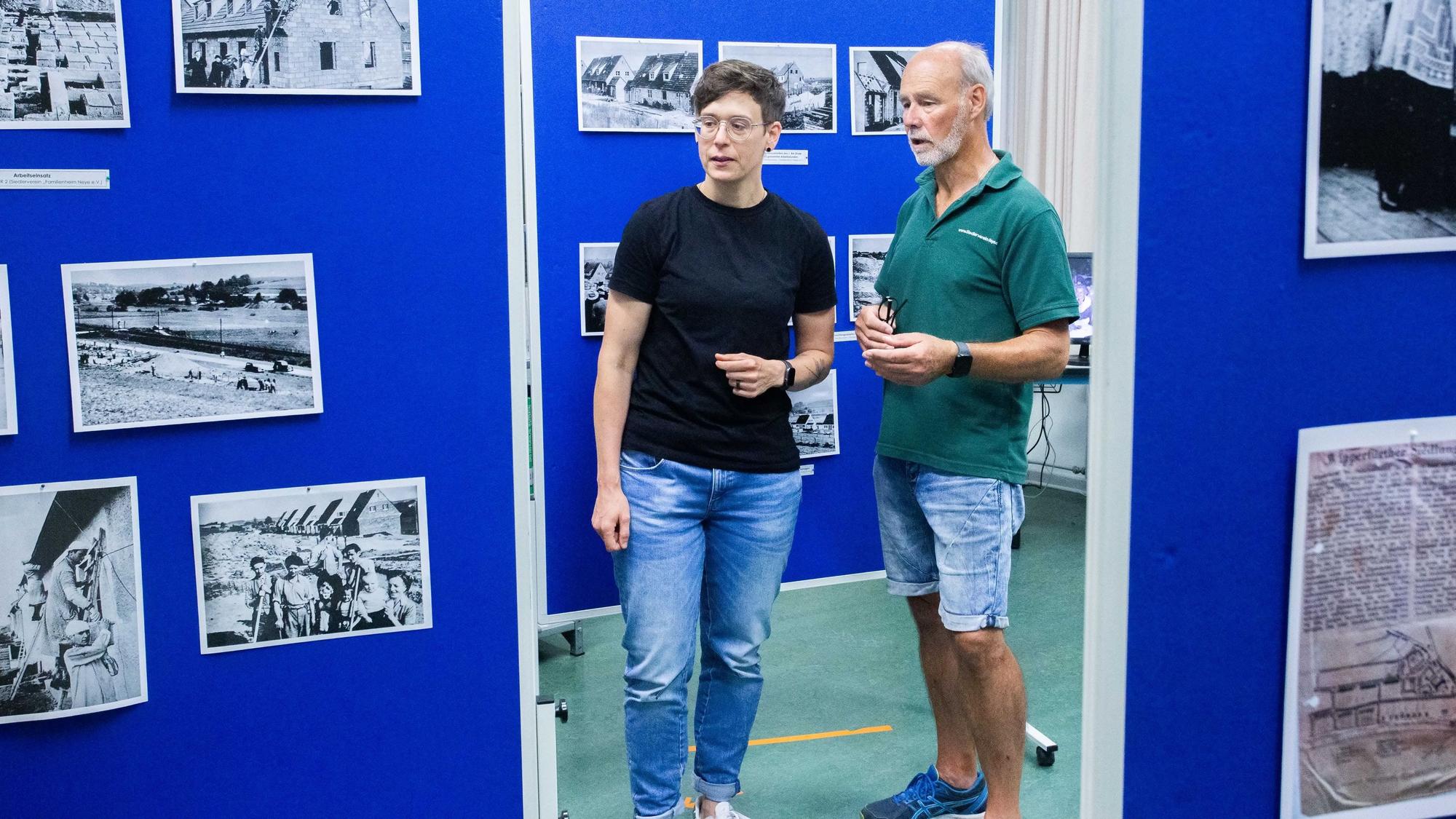 Stadtarchivarin Sarah Zeppenfeld und Wolfgang Blechmann vom Siedlerverein stehen in einer Ausstellung.