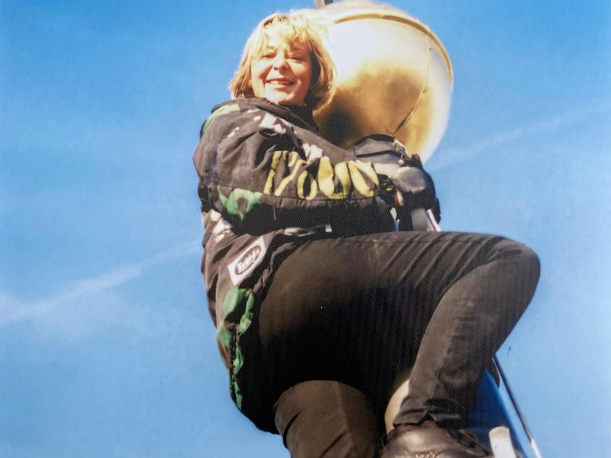 Die Dachdeckerin steht an der Spitze eines Kirchturms.