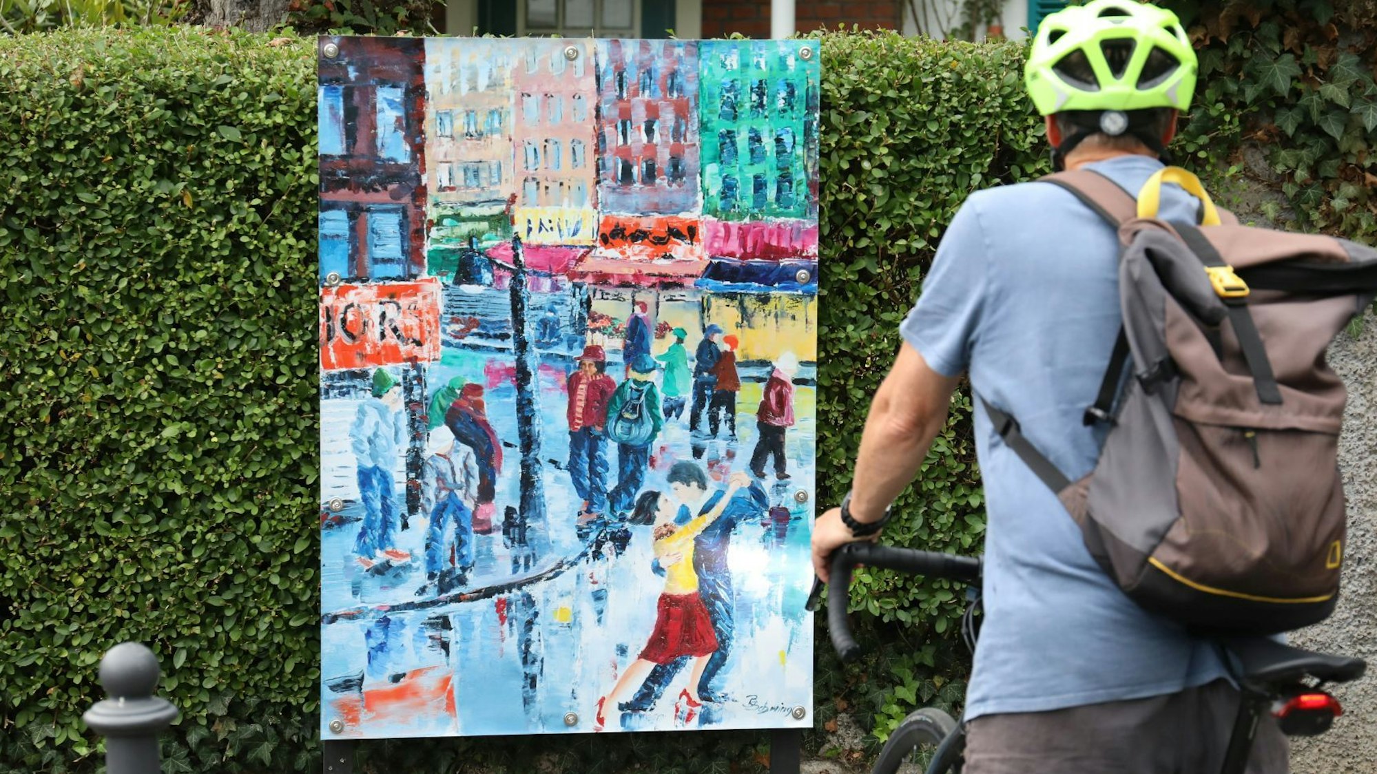 Ein buntes Gemälde mit einer Straßenszene und einem tanzenden Paar.