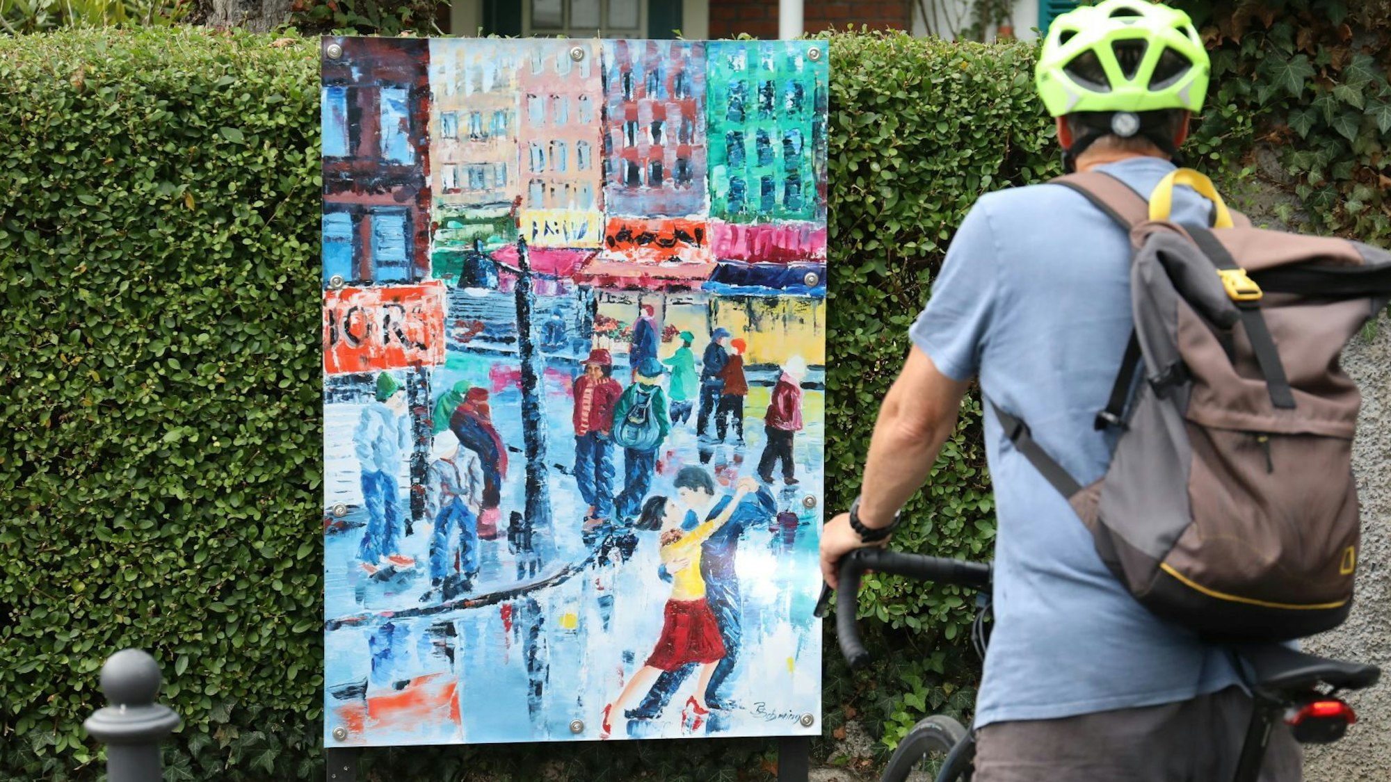 Ein buntes Gemälde mit einer Straßenszene und einem tanzenden Paar.