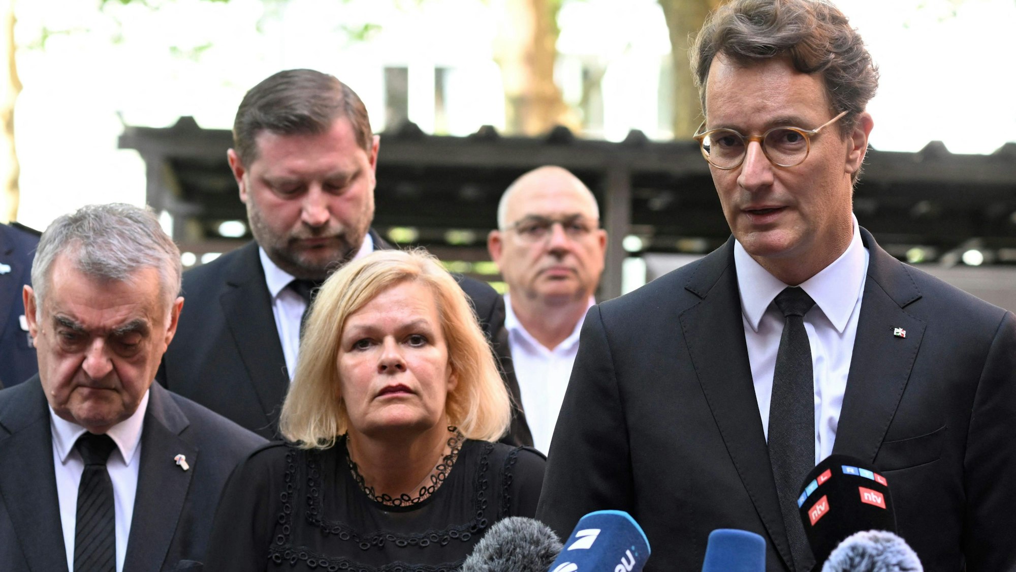 NRW-Ministerpräsident Hendrik Wüst (r.) bei einer Stellungnahme in Solingen.