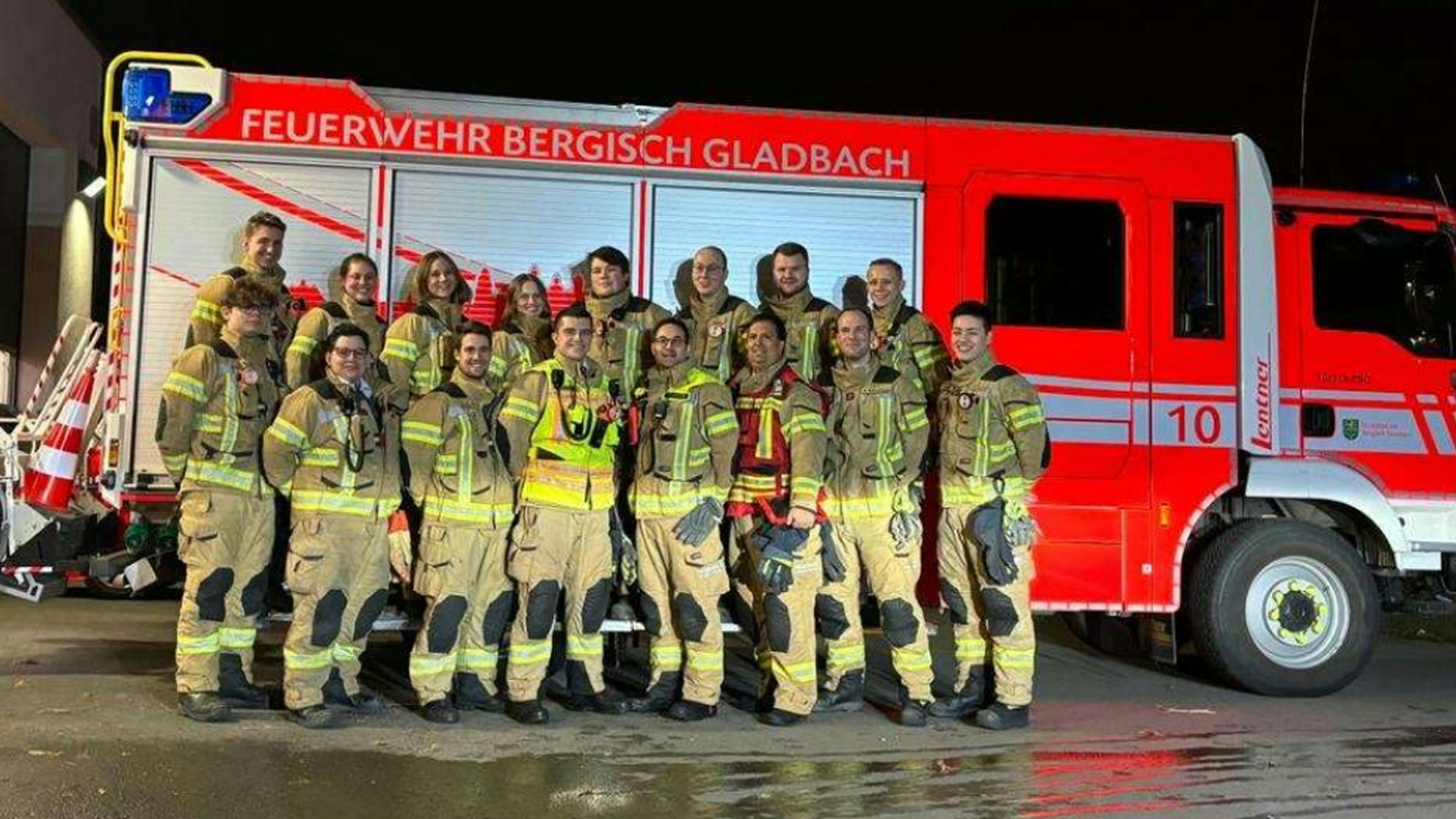 Feuerwehrleute stehen vor einem Löschgruppenfahrzeug.