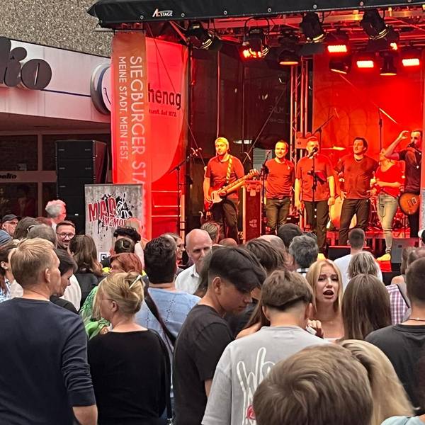 Beim Siegburger Stadtfest feiern Menschen vor einer Bühne.