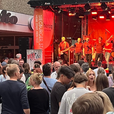 Beim Siegburger Stadtfest feiern Menschen vor einer Bühne.