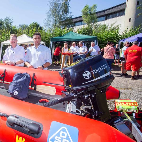 Drei Rettungsschwimmer präsentieren ein neues Rettungsboot.