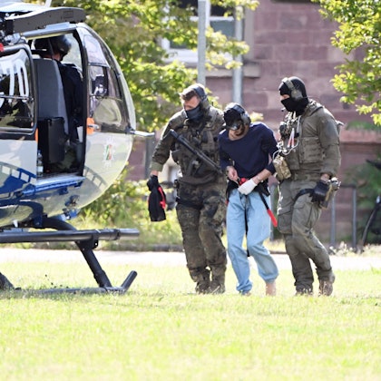 25.08.2024, Baden-Württemberg, Karlsruhe: Der mutmassliche Täter des Messerangriffs von Solingen wird zu einem Hubschrauber gebracht. Zuvor war der Verdächtige dem Ermittlungsrichter beim Bundesgerichtshof (BGH) vorgeführt worden, der Haftbefehl erlassen hat. Foto: Uli Deck/dpa +++ dpa-Bildfunk +++