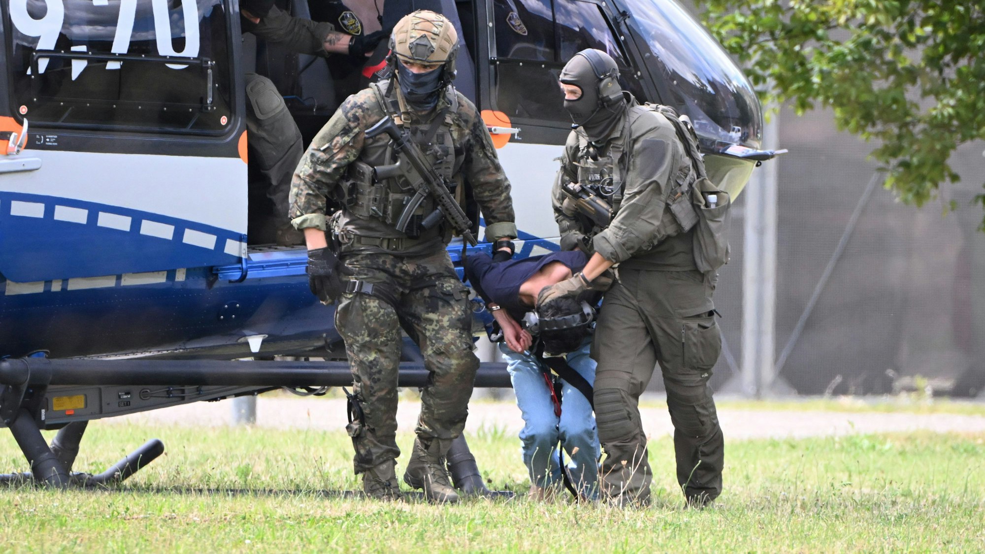 25.08.2024, Baden-Württemberg, Karlsruhe: Der mutmassliche Täter des Messerangriffs von Solingen wird von einem Hubschrauber zu einer Wagenkolonne geführt. Diese bringt ihn zum Ermittlungsrichter des Bundesgerichtshof (BGH), der über einen Haftbefehl entscheiden wird. Foto: Uli Deck/dpa +++ dpa-Bildfunk +++