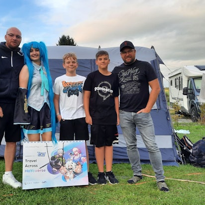 Bild einer Familie vor einem Zelt