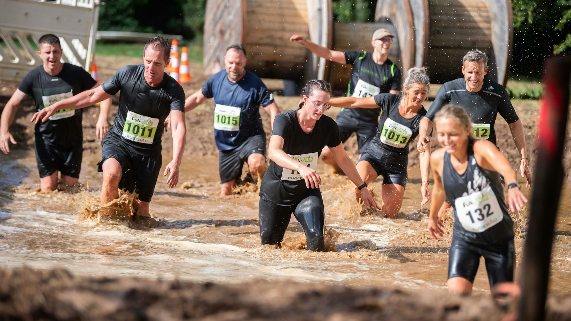 Zahlreiche Teilnehmer eines Sportevents in Euskirchen waten durch den Matsch.