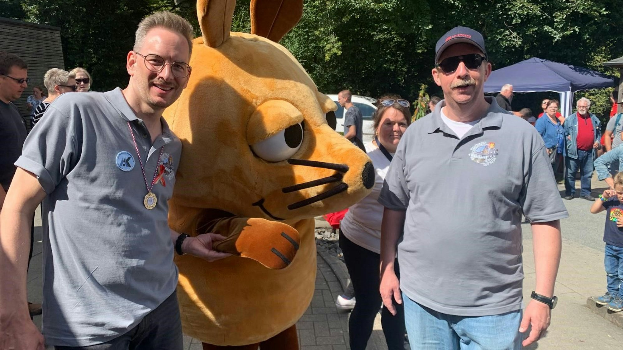 Sebastian Gissinger (links) und Guido Lemmer (rechts) vom Organisationsteam mit der WDR-Maus.