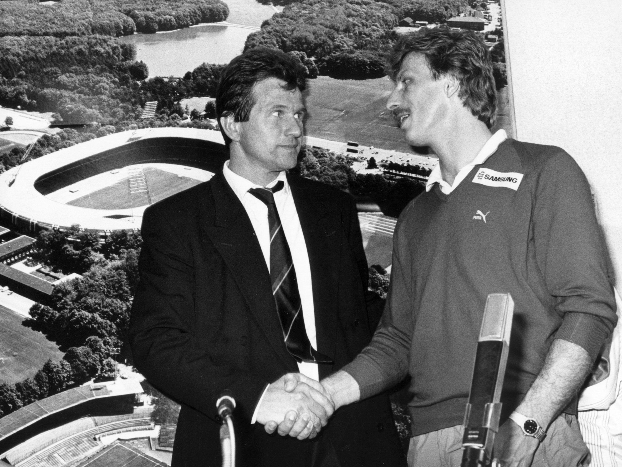 Christoph Daum (r), damaliger Trainer des Fußball-Bundesligisten 1. FC Köln, und damaliger Bayern-Trainer Jupp Heynckes schütteln sich nach dem Spiel im Köln-Müngersdorfer Stadion auf der Pressekonferenz die Hand.