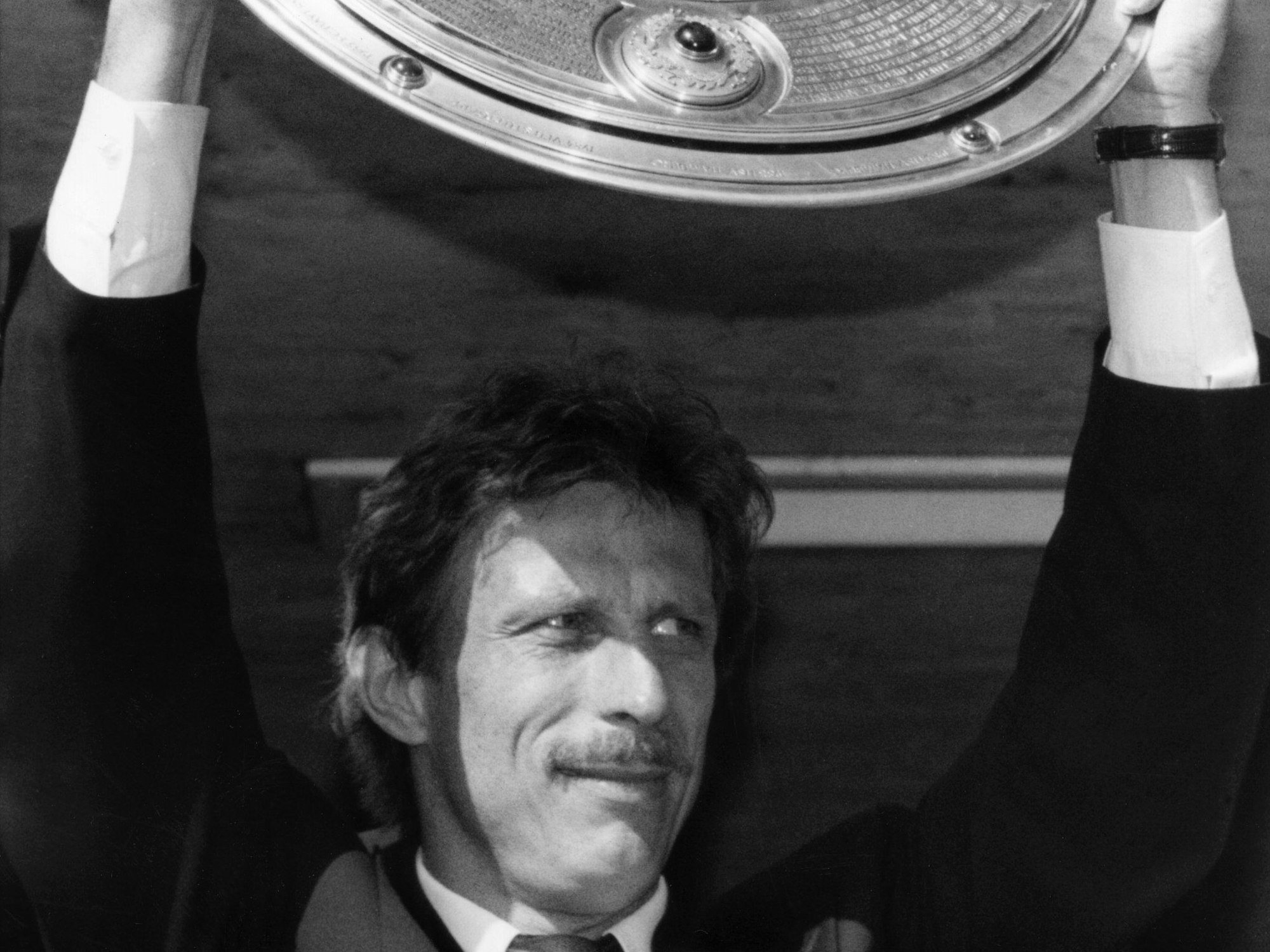 Stuttgarts Trainer Christoph Daum hebt bei einem Autocorso durch Stuttgart triumphierend die eroberte Meisterschale hoch.