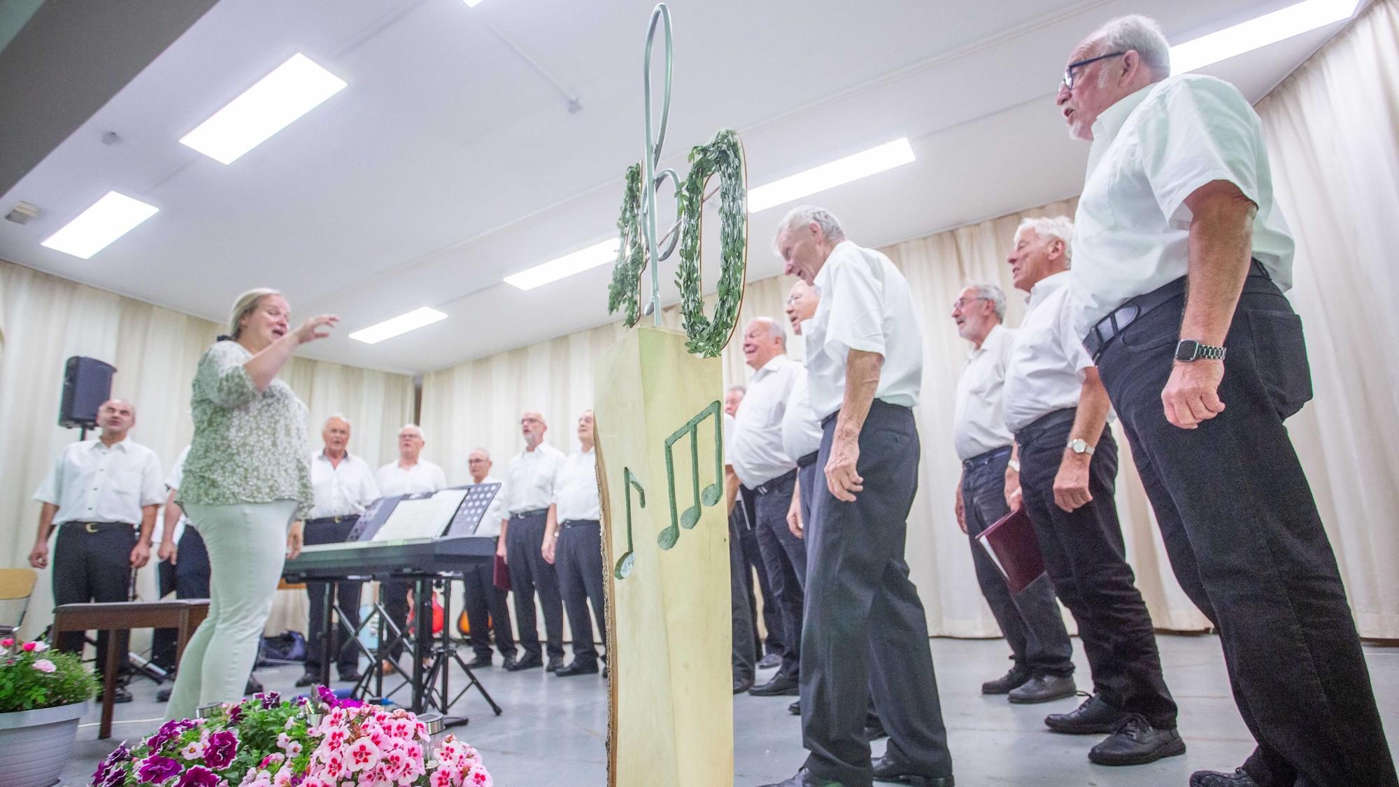 Eine Frau dirigiert einen Männerchor.