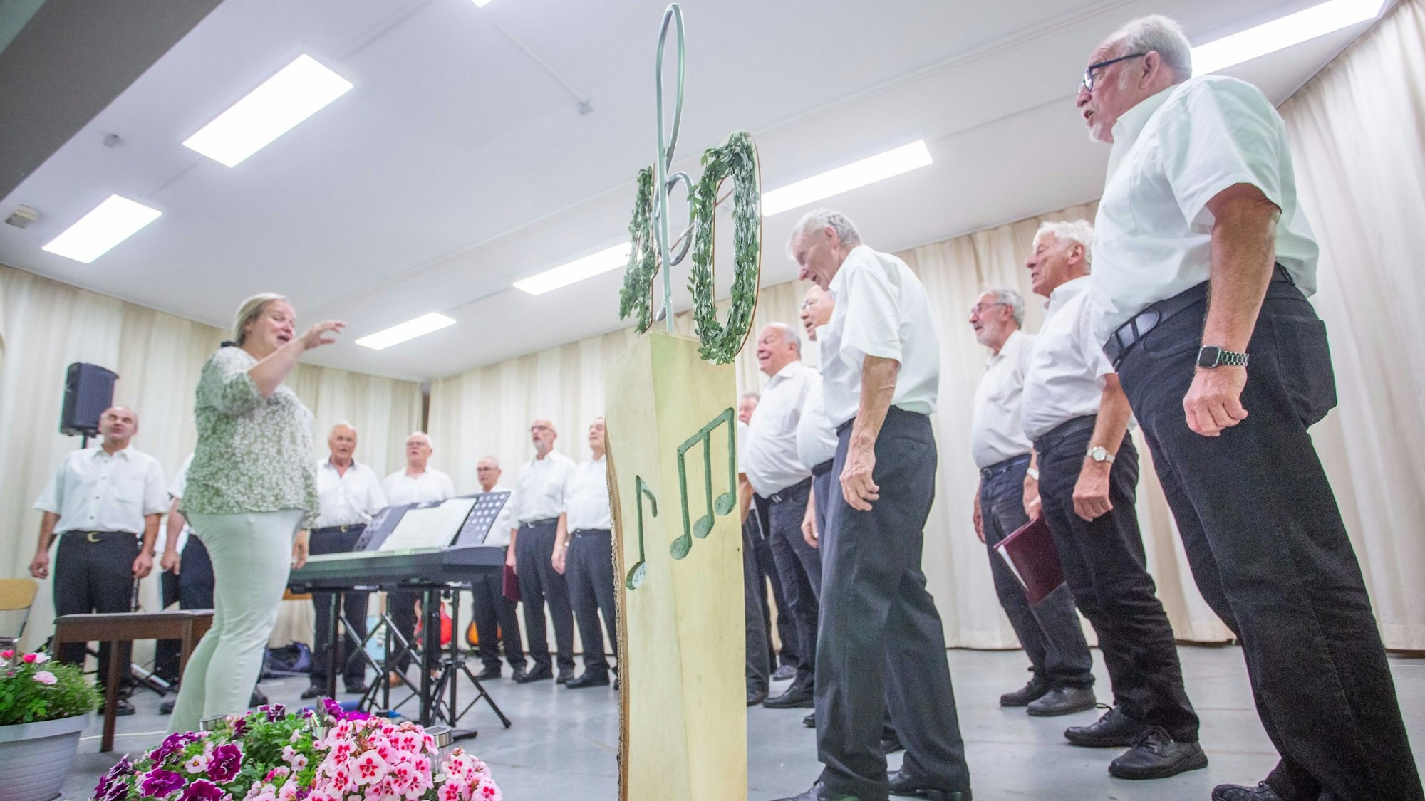 Eine Frau dirigiert einen Männerchor.