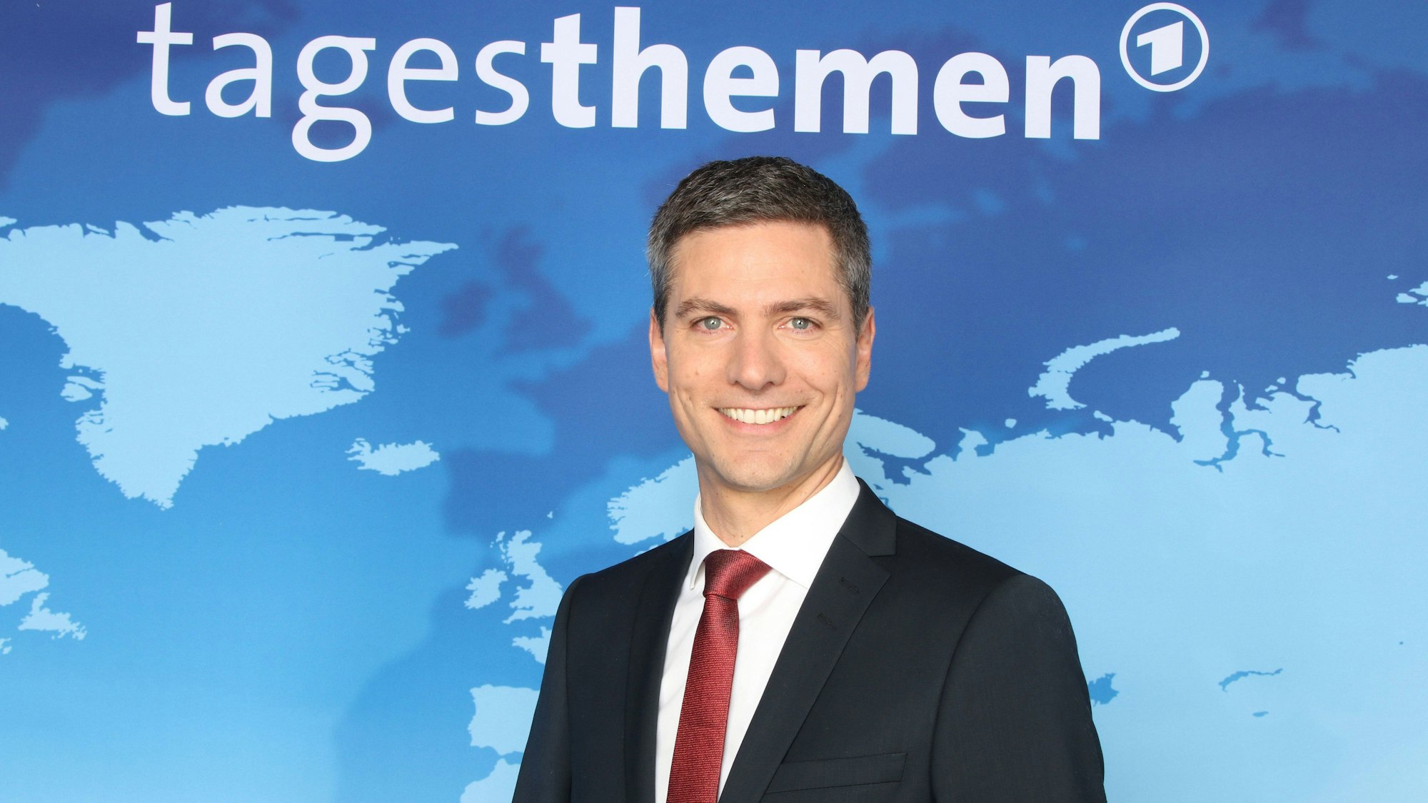 Tagesthemen-Moderator Ingo Zamperoni lacht in die Kamera.