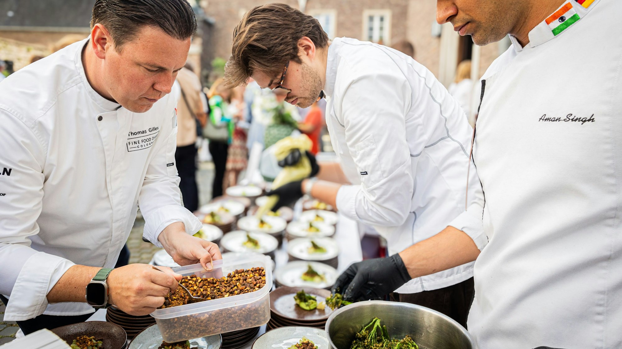 Küchenchef Thomas Gilles (links) vom „Clostermanns Hof“ richtet die Teller für gut 450 Gäste an.