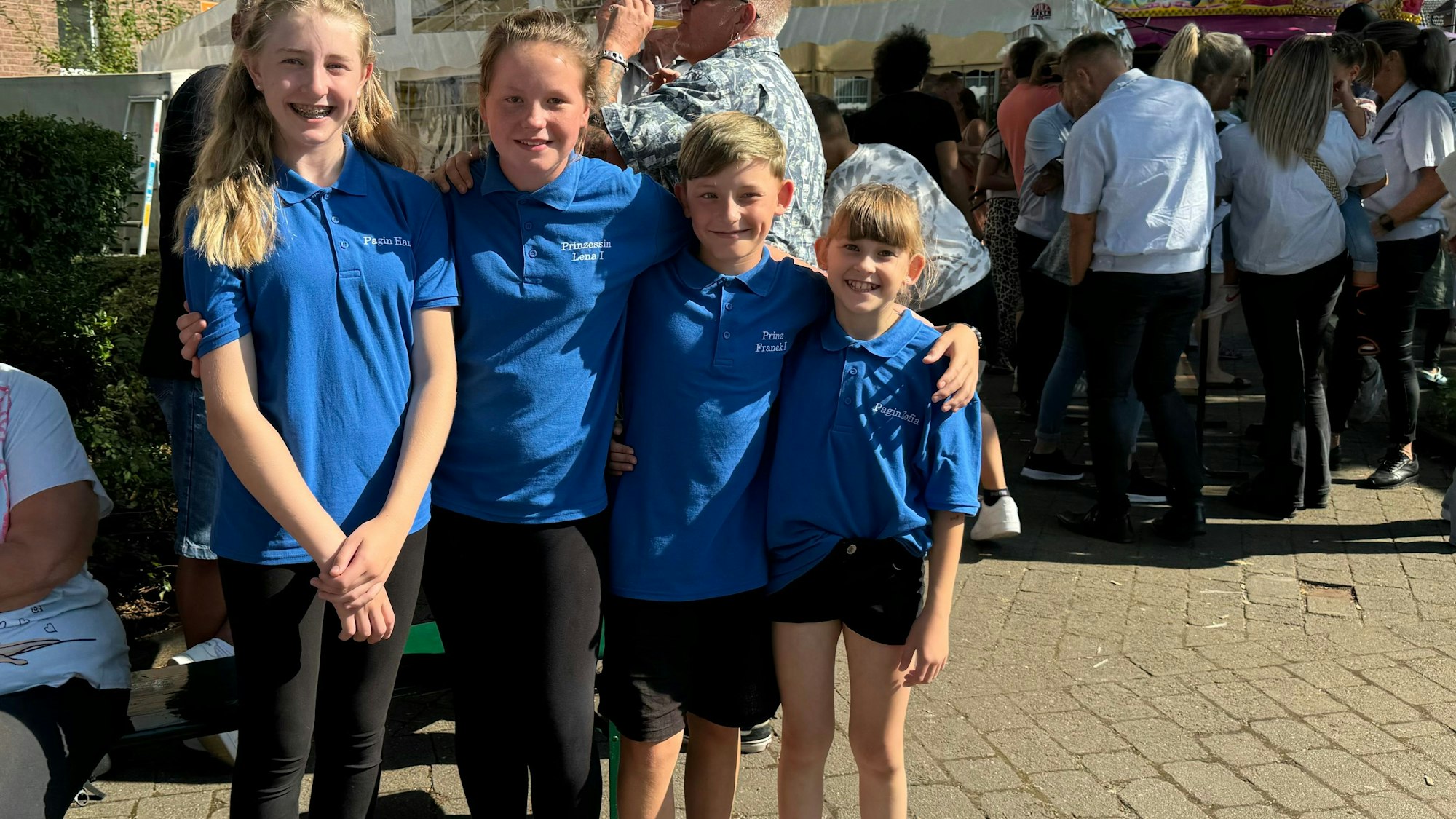 Ein Junge und drei Mädchen lächeln in die Kamera.