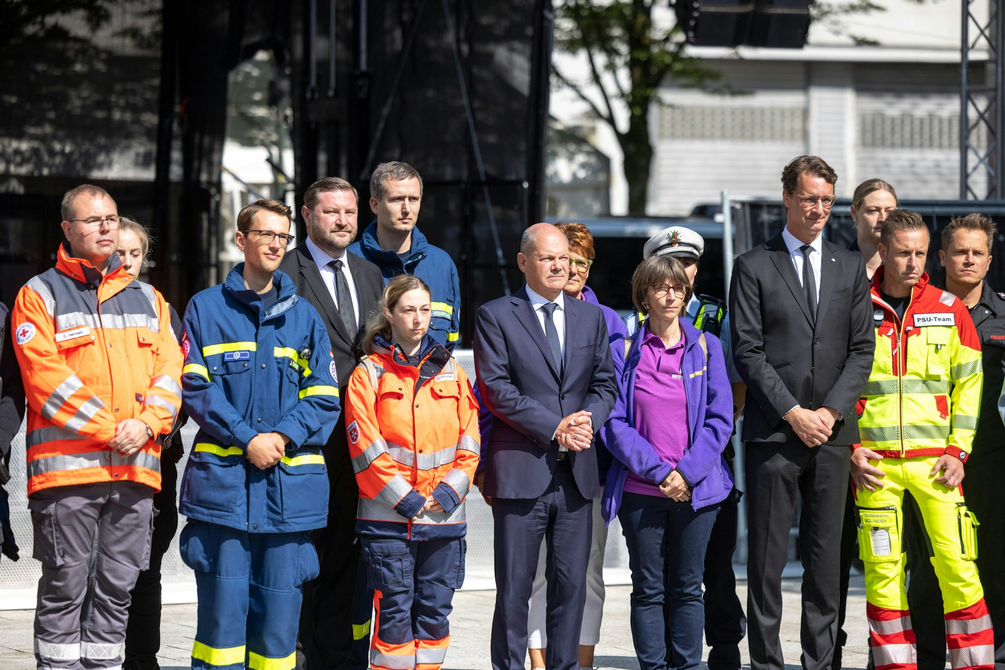 Tim Kurzbach (SPD, 4.v.l), Oberbürgermeister von Solingen, Bundeskanzler Olaf Scholz (SPD, M) und Hendrik Wüst (CDU 4.v.r.), Ministerpräsident von Nordrhein-Westfalen, stehen gemeinsam mit den Einsatzkräften für ein Gruppenbild zusammen.