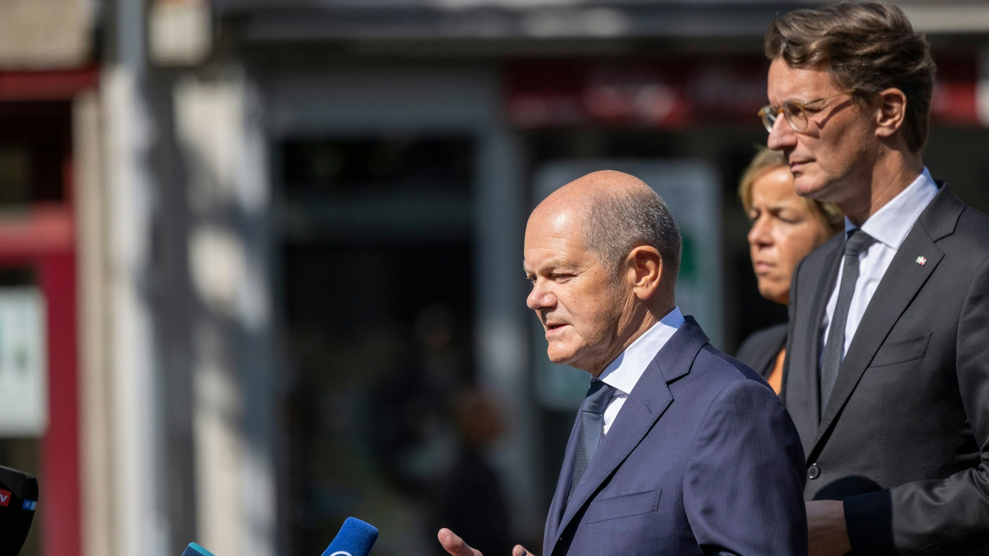 Solingen: Bundeskanzler Olaf Scholz (l-r SPD) spricht im Beisein von Mona Neubaur (Grüne), stellvertretende Ministerpräsidentin von Nordrhein-Westfalen, und Hendrik Wüst (CDU), Ministerpräsident von Nordrhein-Westfalen, vor der Presse in der Nähe des Tatorts.