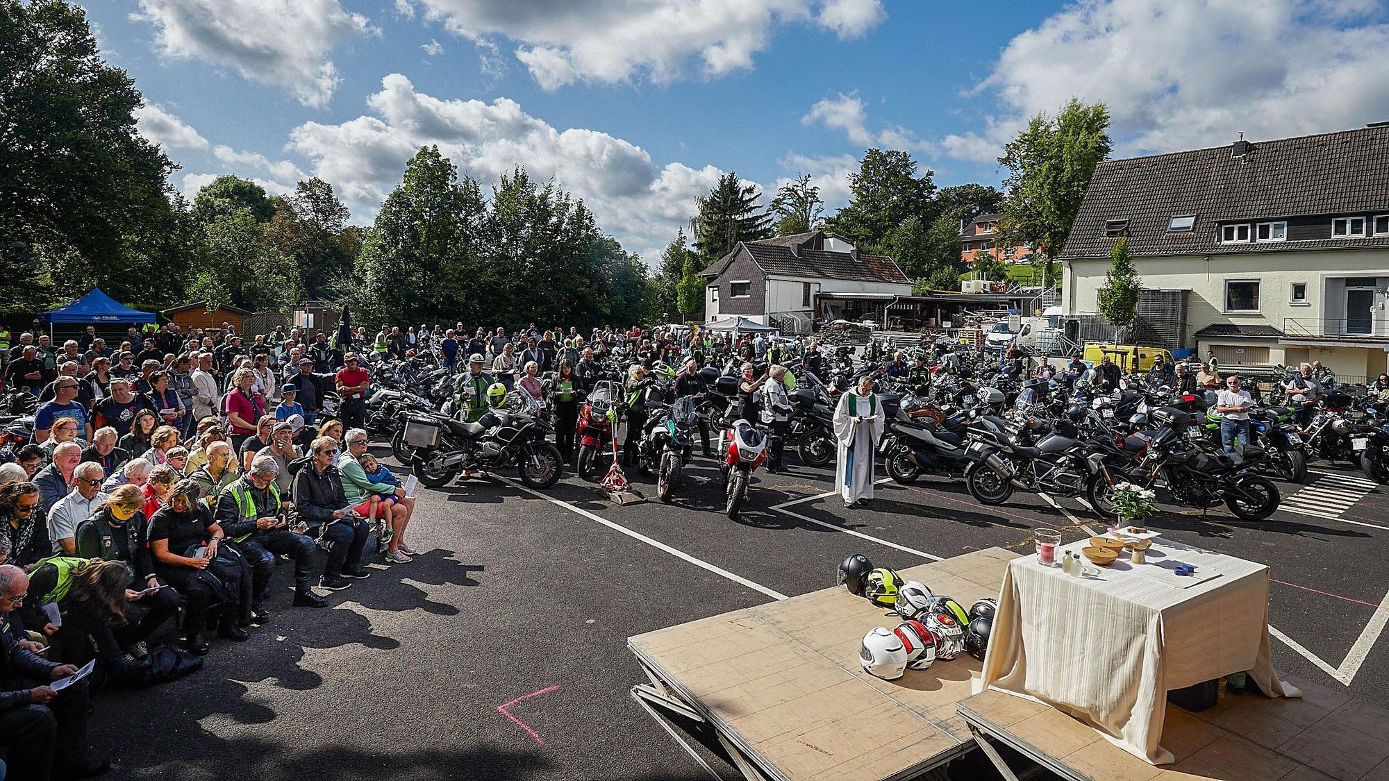Die Motorräder stehen auf der rechten Seite vor dem Altar. Auf der anderen Seite sitzen die Fahrer.