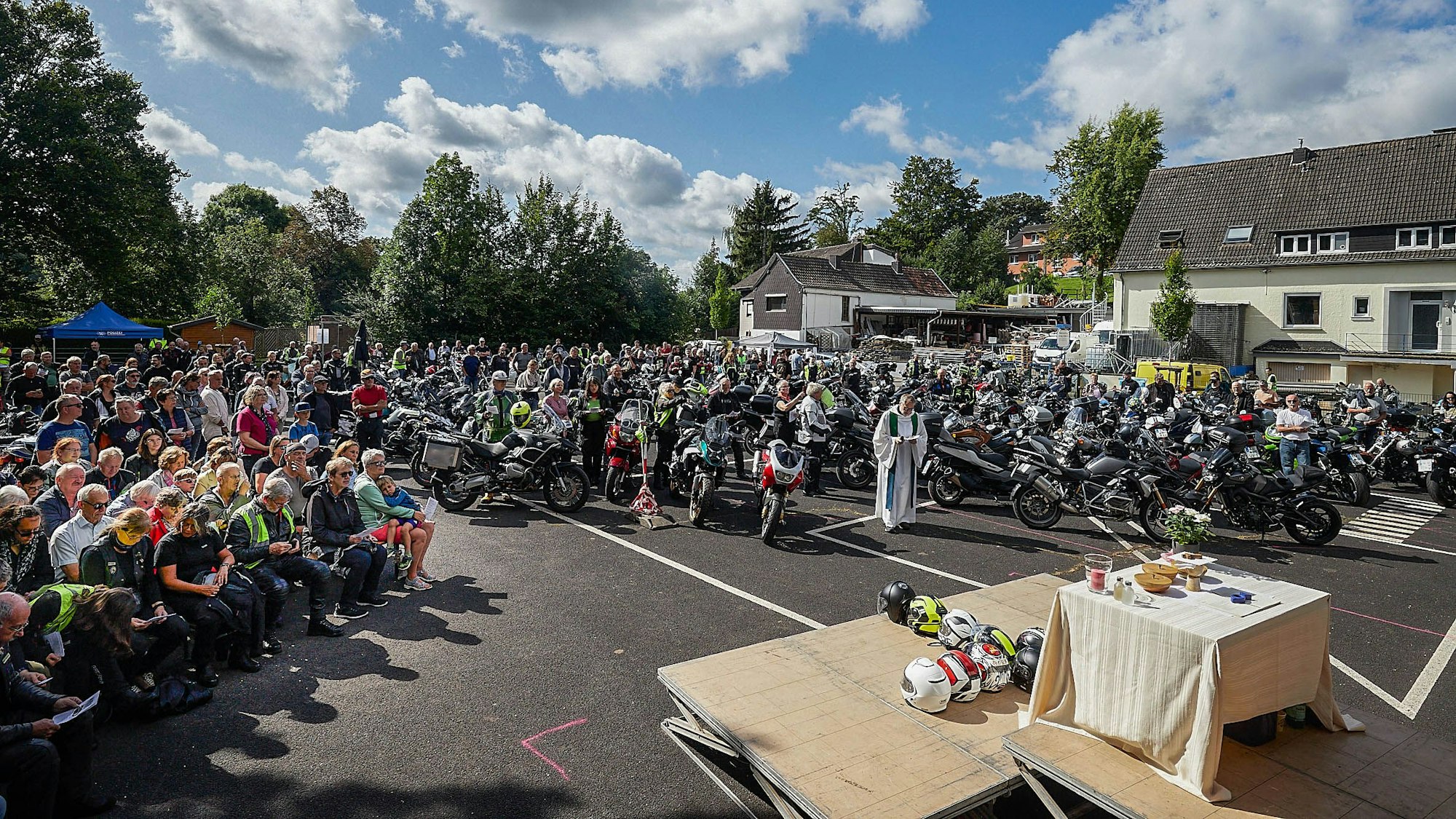 Die Motorräder stehen auf der rechten Seite vor dem Altar. Auf der anderen Seite sitzen die Fahrer.