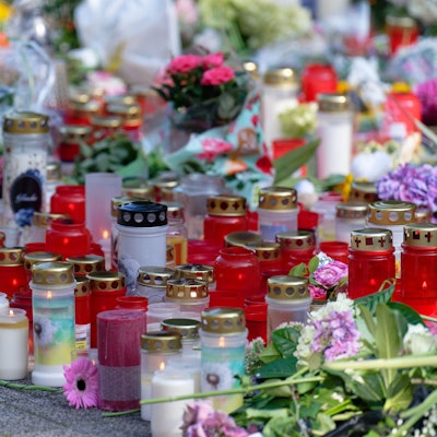 Solingen: Blumen und Kerzen in Gedenken an die Opfer liegen an einer Kirche in der Nähe des Tatorts. Viele Menschen haben Blumen und Kerzen zum Gedenken an die Opfer in der Nähe des Tatorts abgelegt.