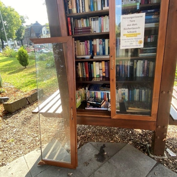 Auf dem Bild ist der Bücherschrank mit der heraus gerissenen Tür zu sehen.