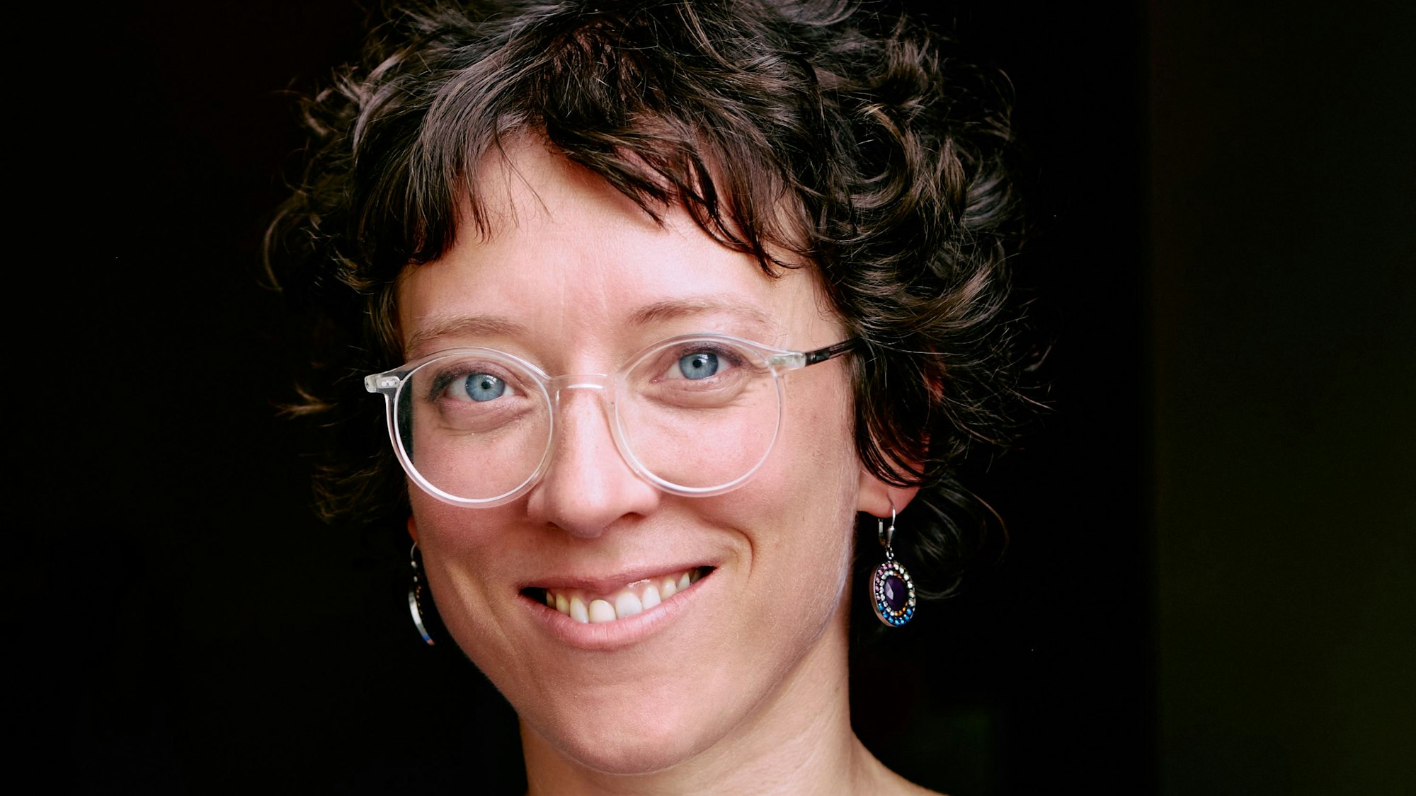 Ein Porträtfoto von Ruth Dobernecker. Sie trägt eine blaue Bluse.